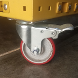 Close-up of a yellow caster wheel with red tire on a metal bracket.
