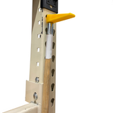 Yellow pull pole end on a pole hanging in teardrop shaped hole on shelf rack